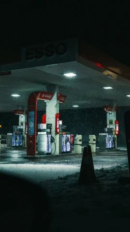a gas station has the dark in the foreground and snowy lights over the ground