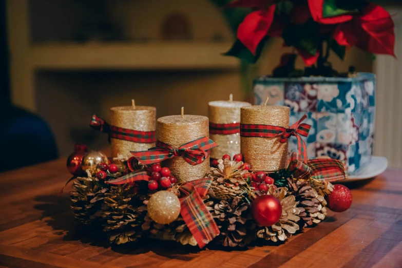 candles and christmas decorations sit beside a cup on a table