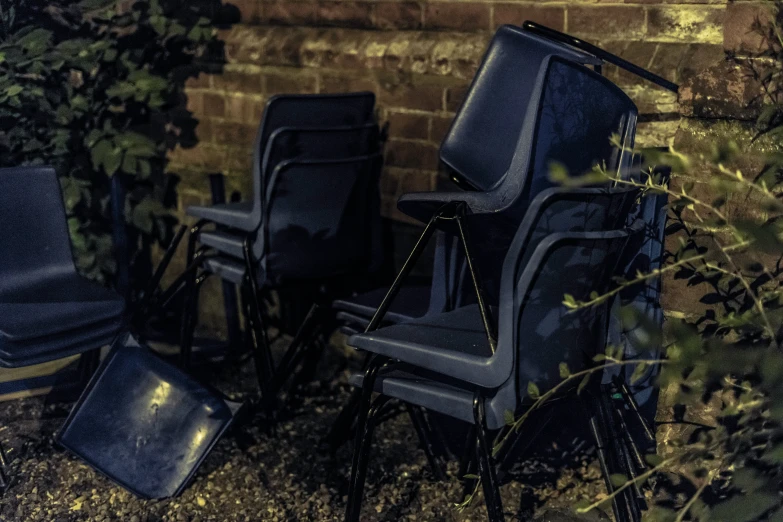 an upturned chair next to two recliners and a trash can