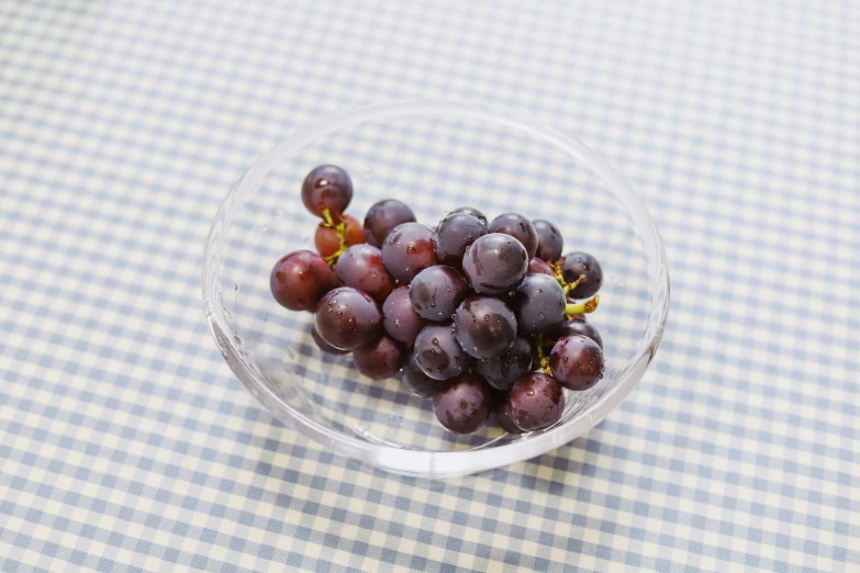 a small bowl of gs on top of a blue checkered table cloth