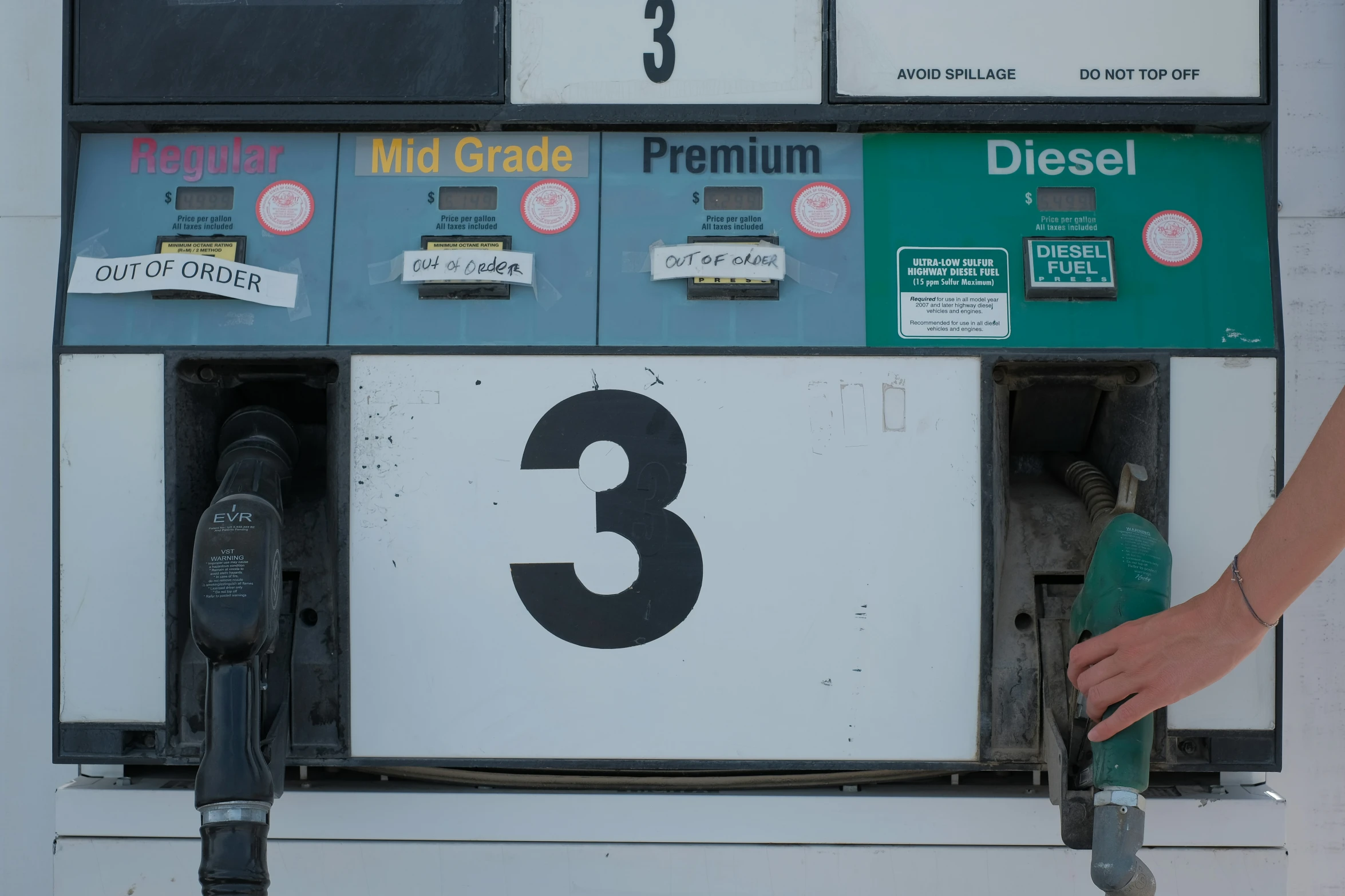 the person is filling their car at the gas station