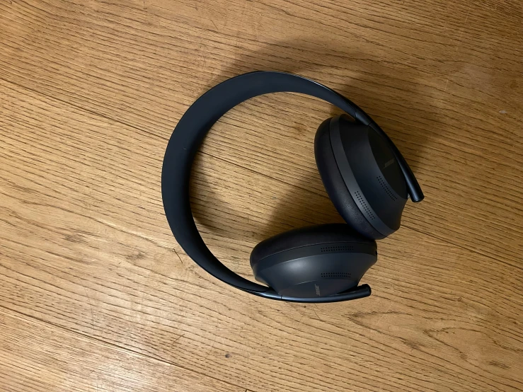black headphones are sitting on a wooden floor