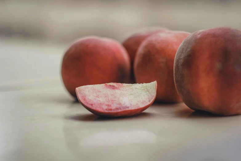 three peaches that are sitting on the ground