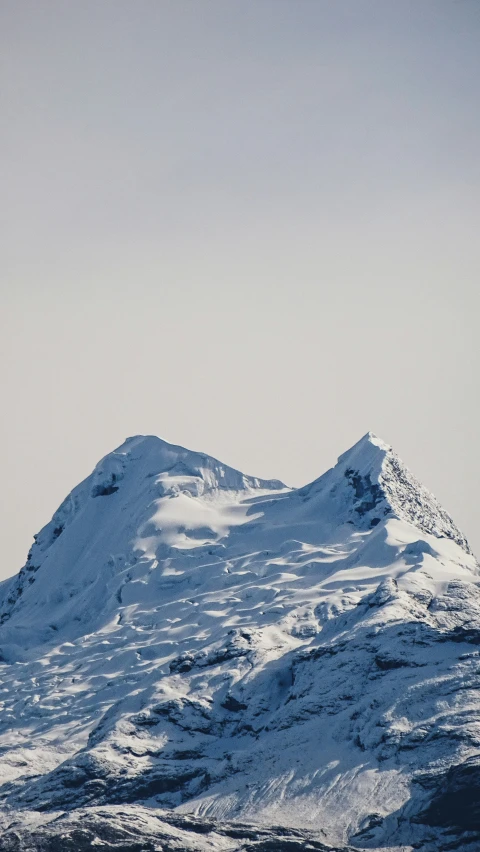 a very tall snowy mountain with snow on it