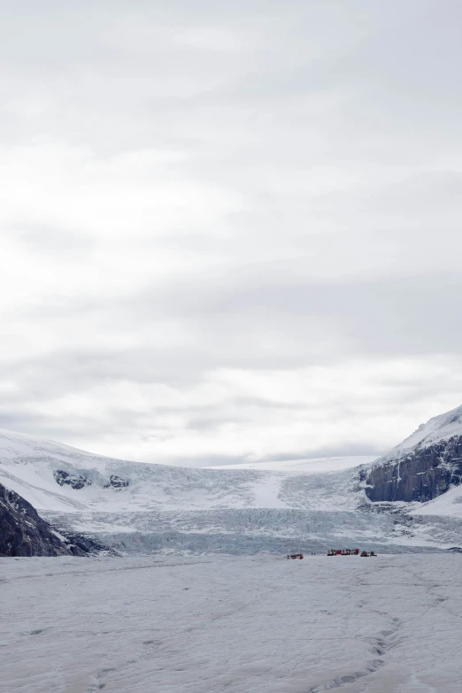 snow covered landscape with small mountains in the distance