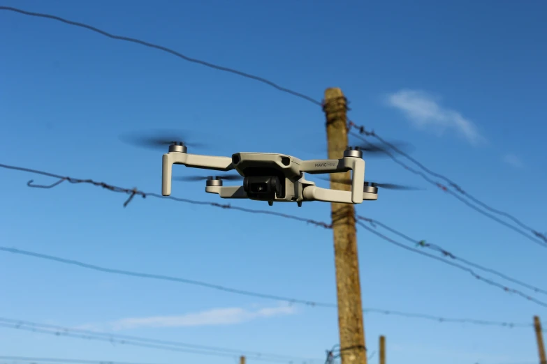 a camera suspended off a wooden pole with power lines in the background