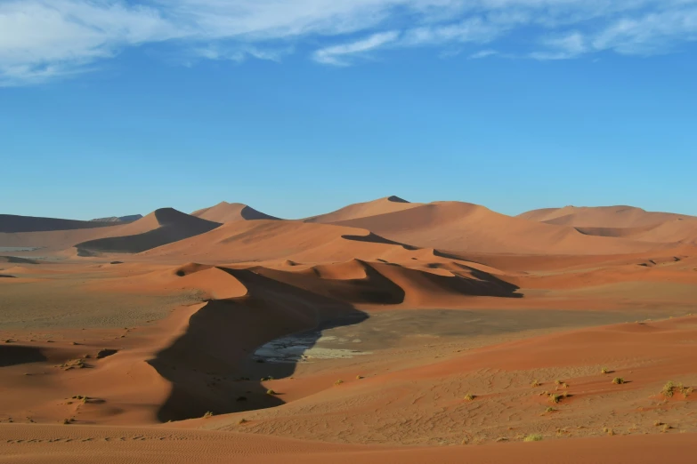 sand dunes in the desert with small water hole