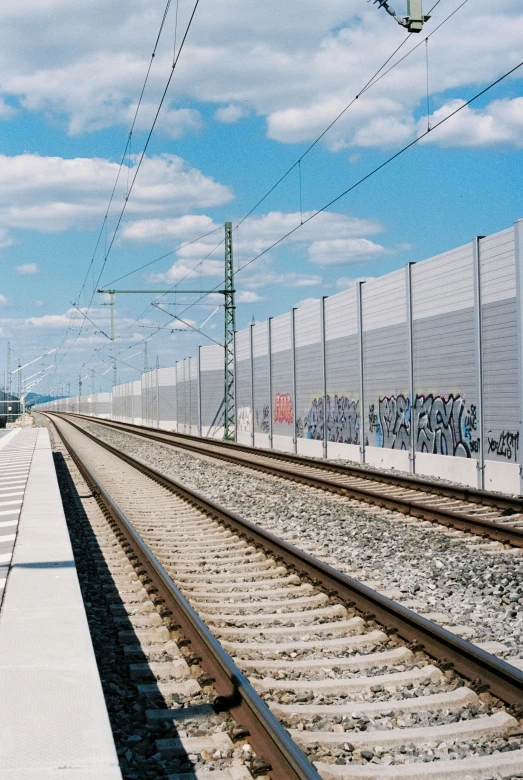 a train track lined with lots of graffiti