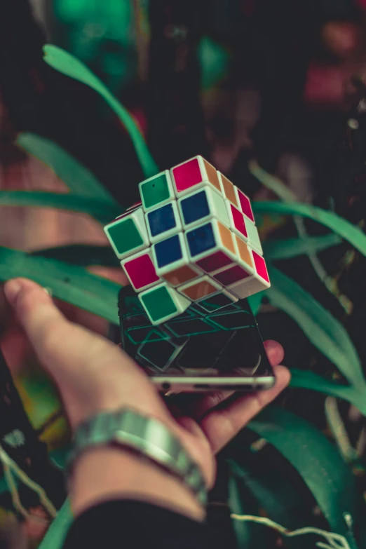 a rubik cube being held up by a hand