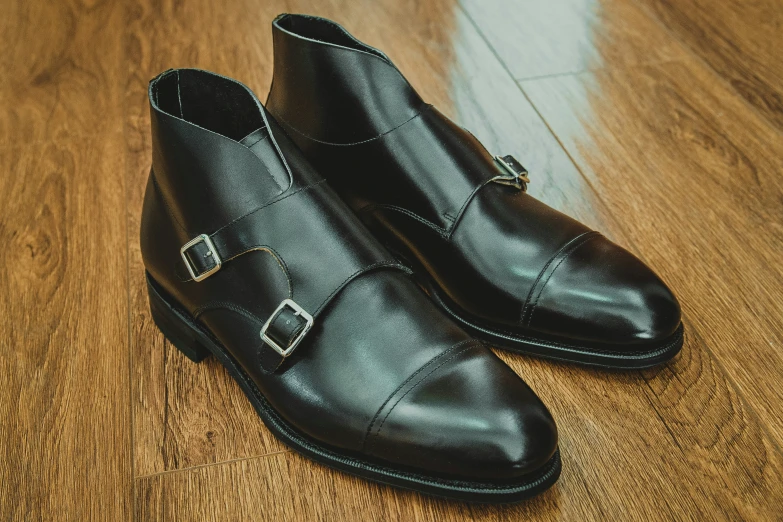 a pair of black shoes sitting on top of a wooden floor