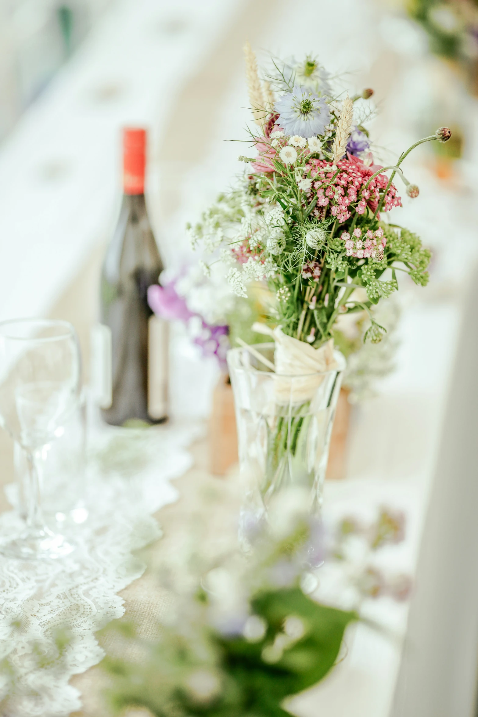 some bottles, wine and glassware sit on a table