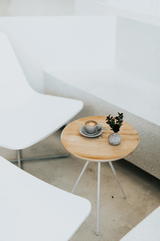 small round table sitting on concrete with a coffee cup next to it