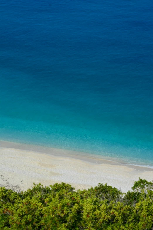 two people are walking along the beach and they are near a water way