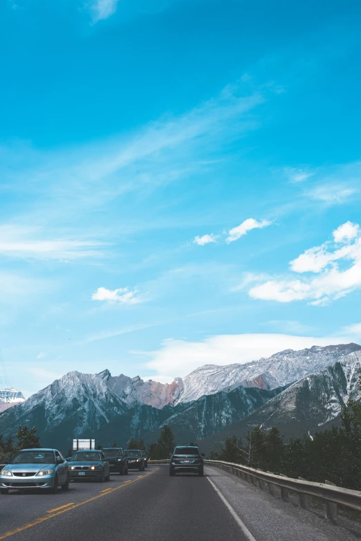 cars travel down the road near mountain range