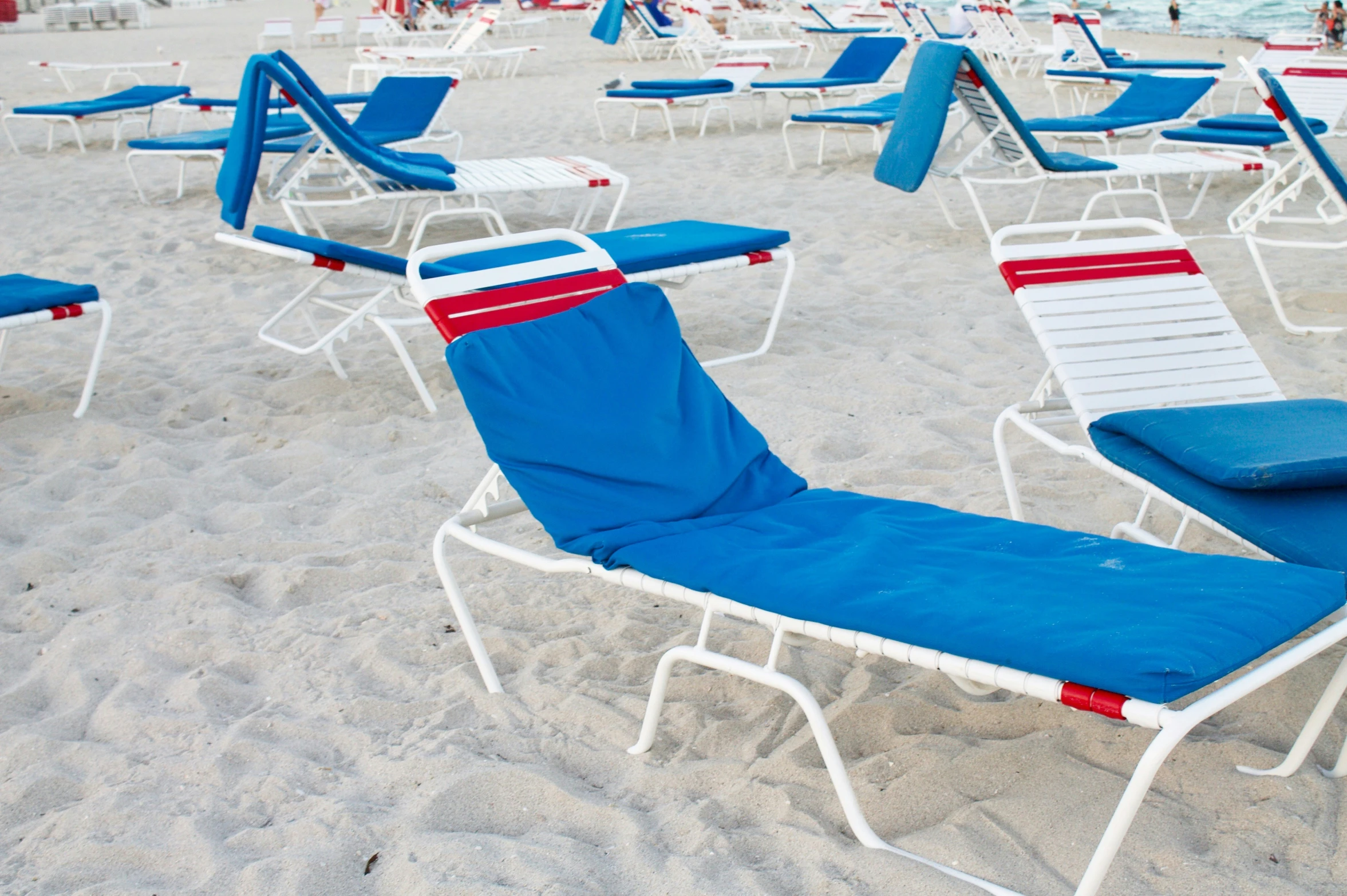 many chairs in the sand on a beach