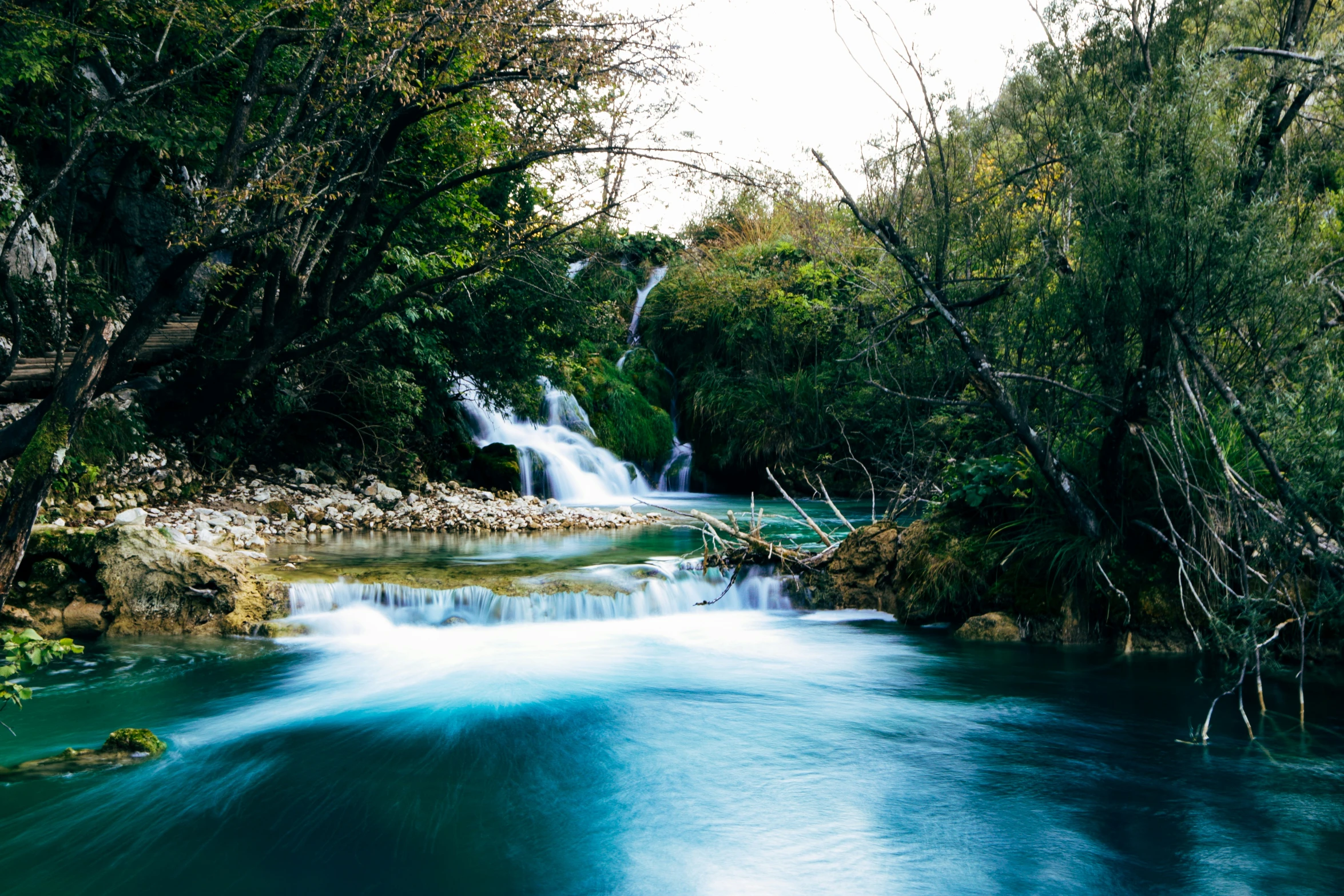 a waterfall with green water in the middle of it