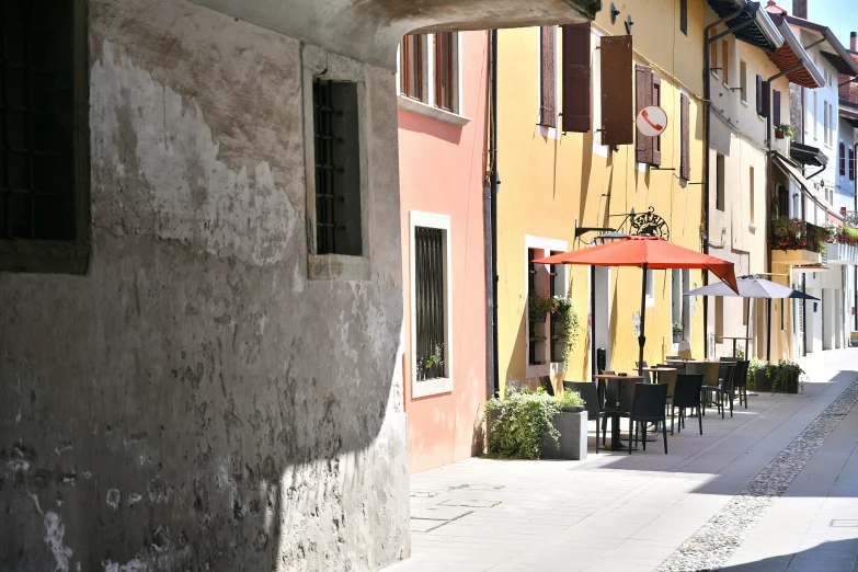 this is an image of several tables and chairs under an umbrella