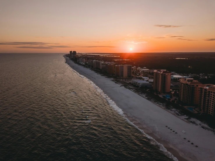 the sun is setting at the beach