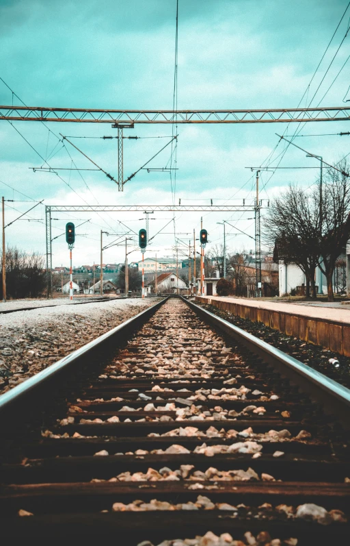 a lone train tracks running beneath a cloudy blue sky