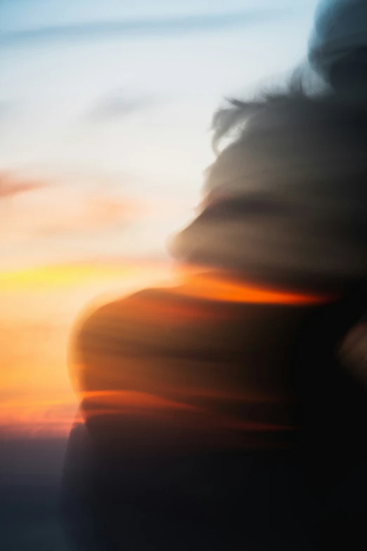 blurred woman's face with the sunset as a background