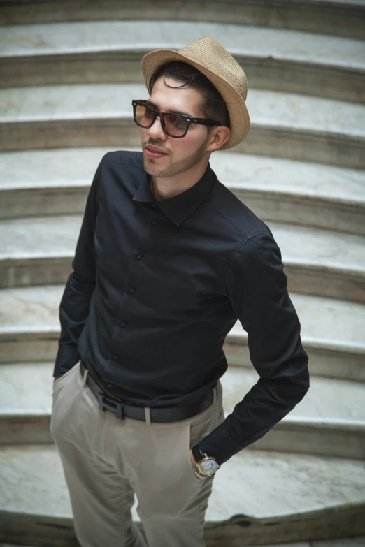 a man in hat and sunglasses standing near some steps