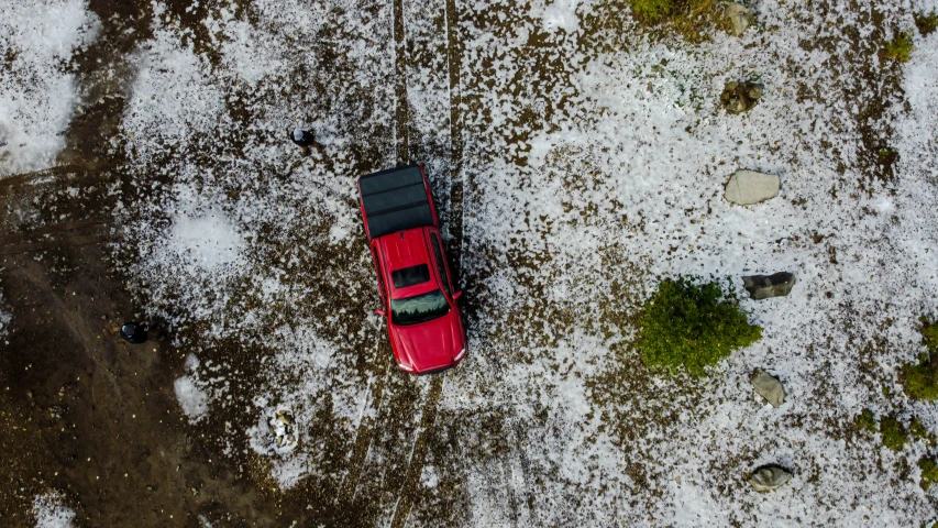 a small red car sitting on top of snow covered ground