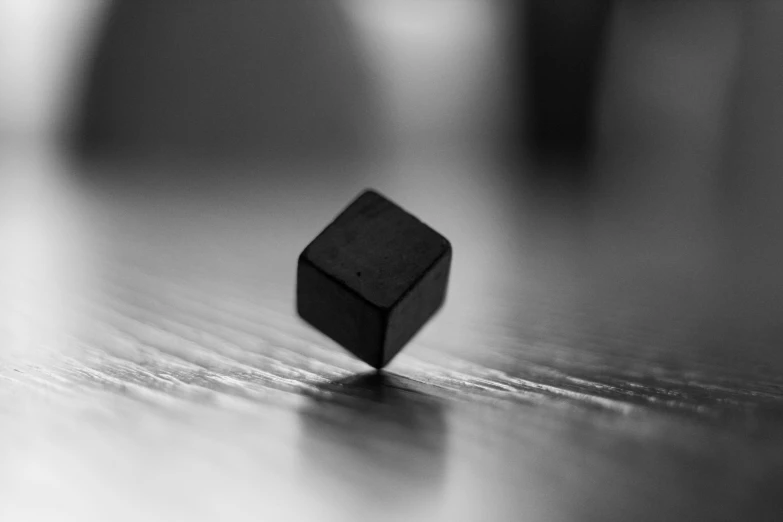 a black cube is laying on a table