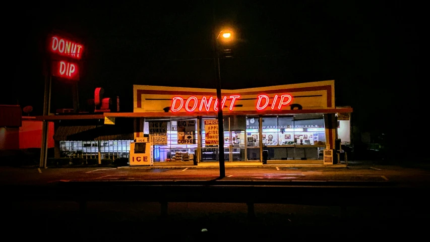 an empty drive through movie shop at night