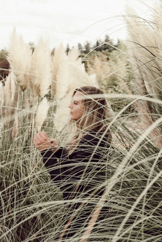 two young women are in a field and one is carrying a baby