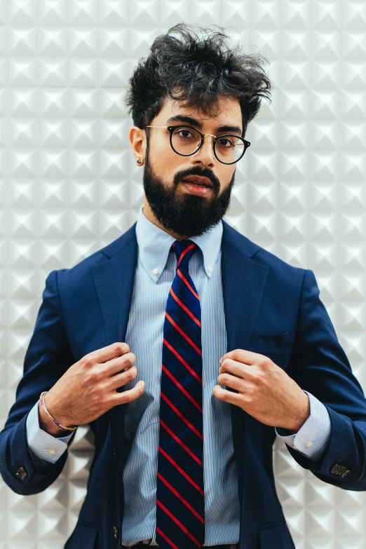 a man in business attire is adjusting his tie