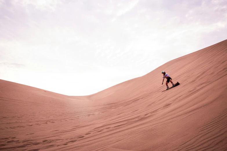 a person standing on top of a sandy hill