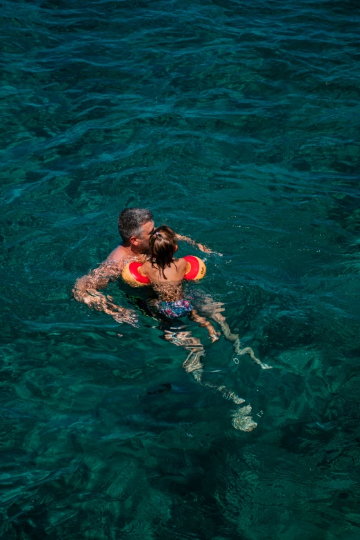 a young couple is swimming in the clear water