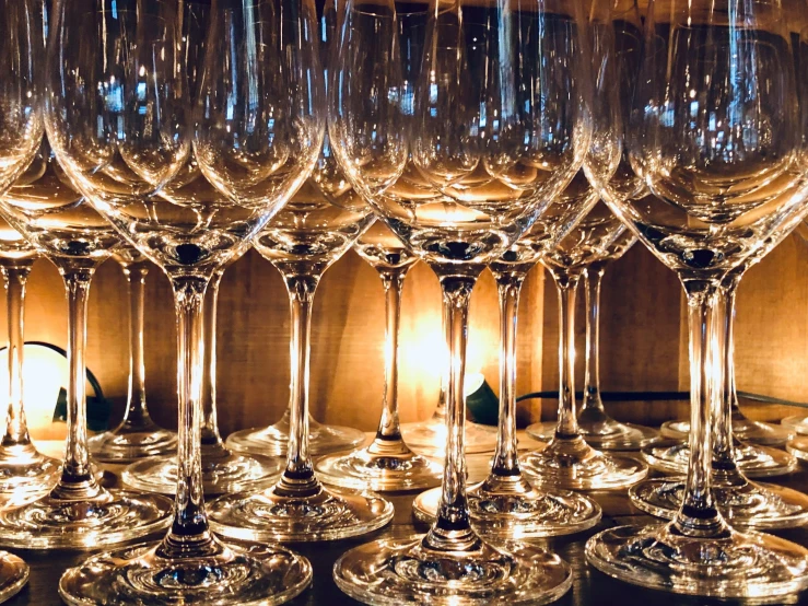 many wine glasses sitting on a table next to each other