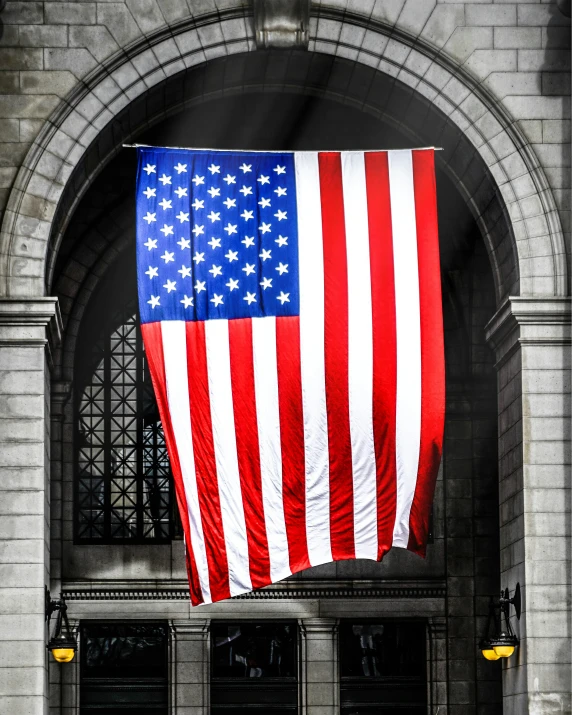 an american flag being lowered by a crane on the wall