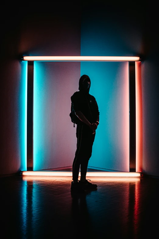 a man standing in front of a neon room