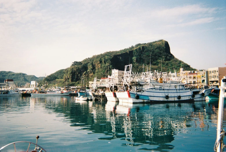 boats docked at a dock next to mountains