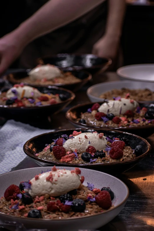 many servings of a dessert with cream and fruit on a table