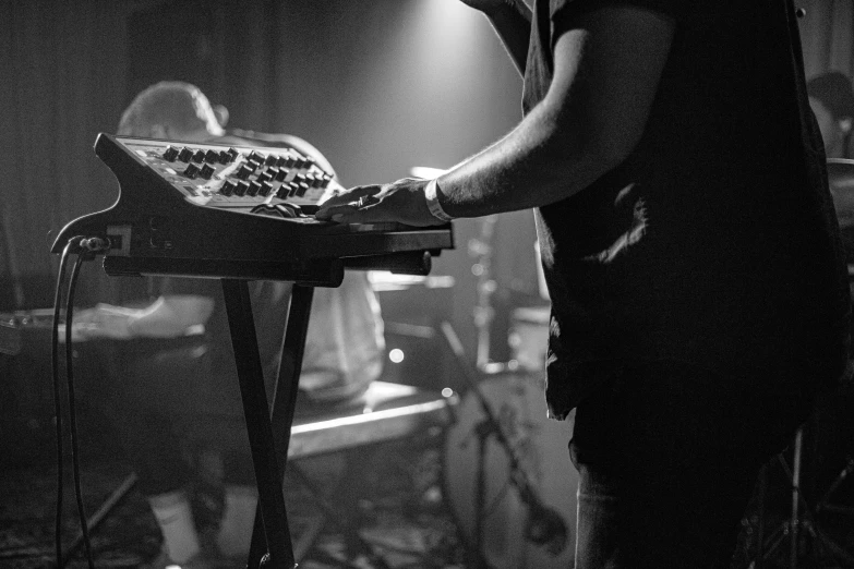 a man with an instrument stands next to a stage in a darkened room