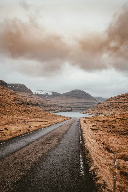 a long and winding road sits in the middle of the mountain pass