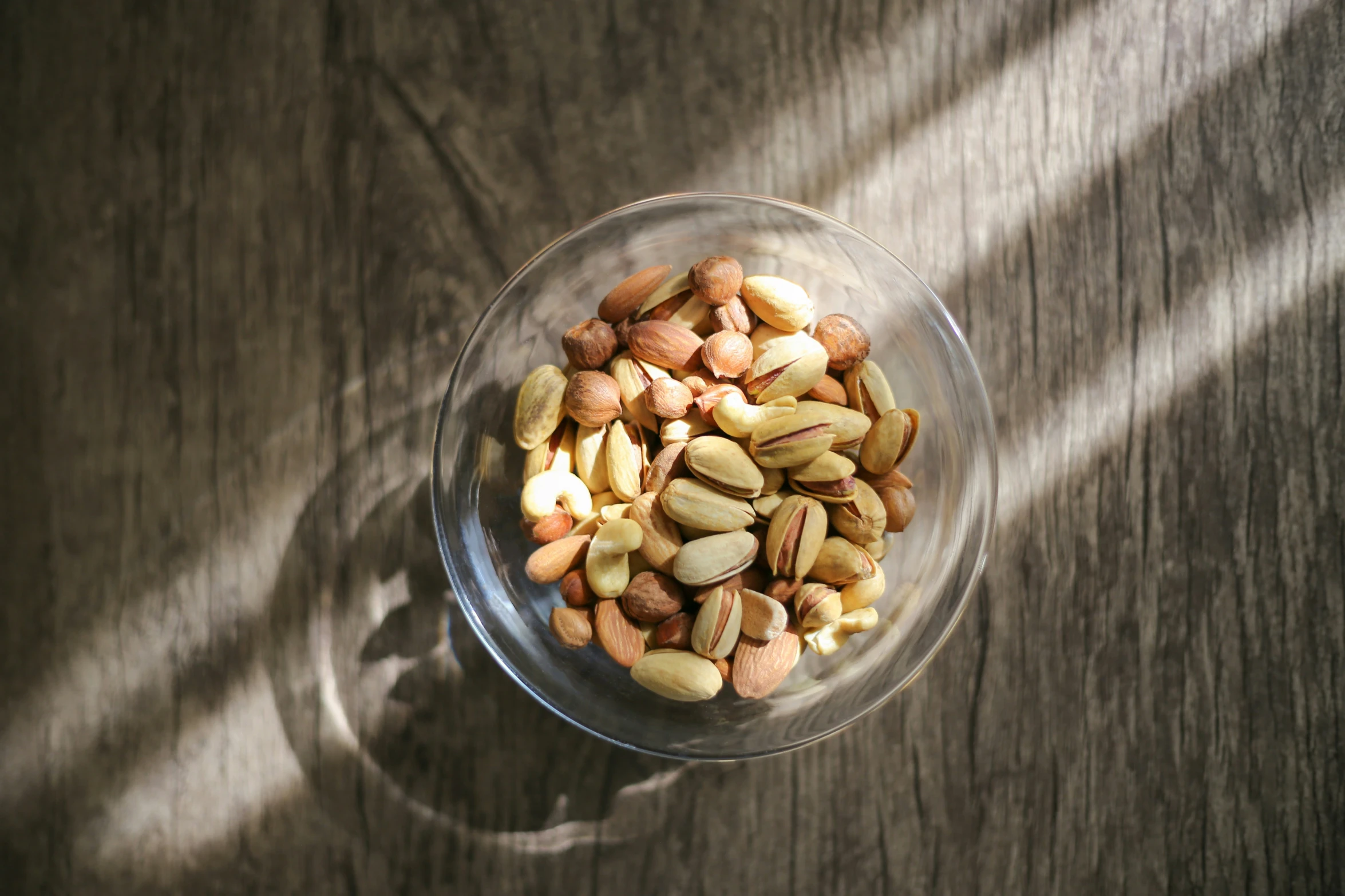 nuts in a glass bowl on a wooden table