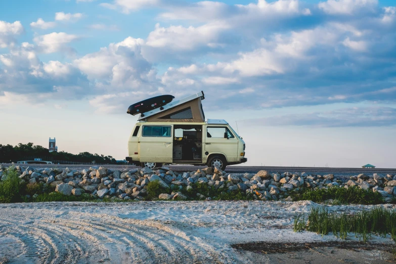 a van with the roof open parked in front of rocks