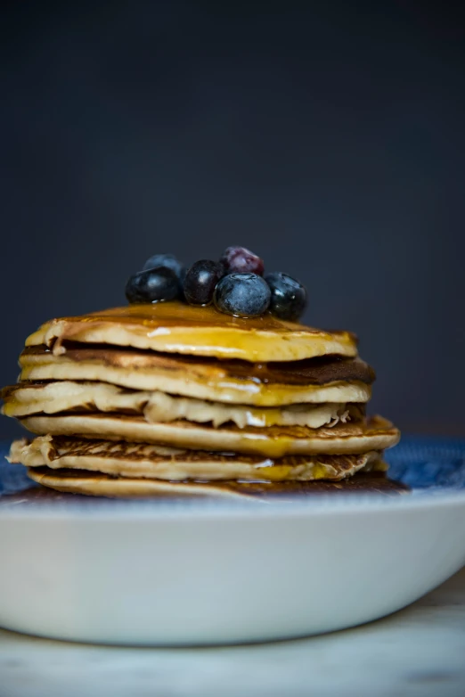 blueberries are sitting atop some pancakes on the plate