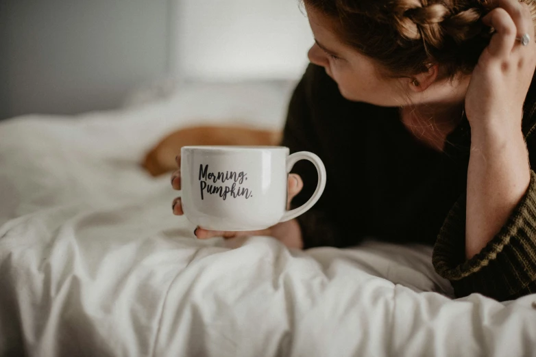 a woman holding a coffee mug with a phrase saying, happy new year