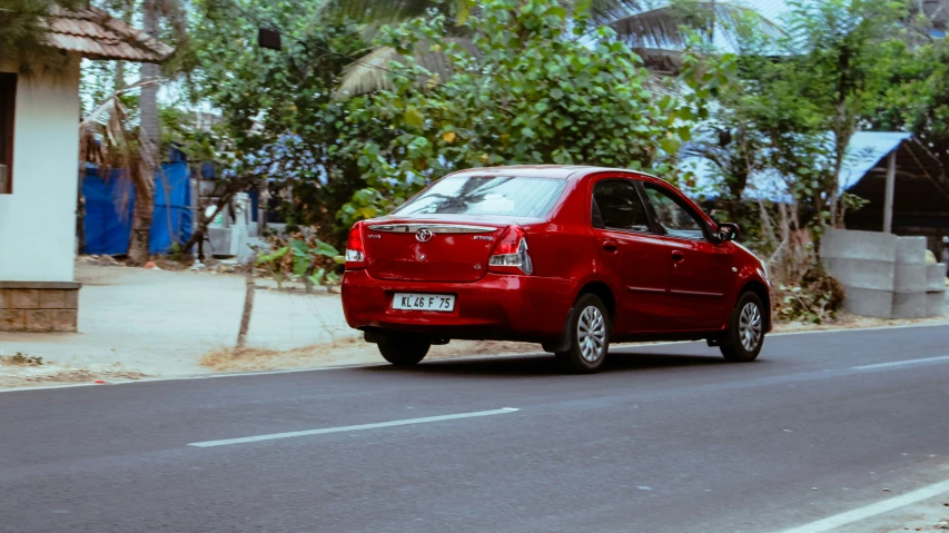 an orange compact car is seen on the street