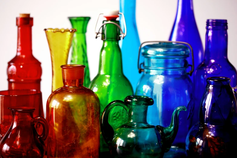 the glass pitchers are lined up together in different colors