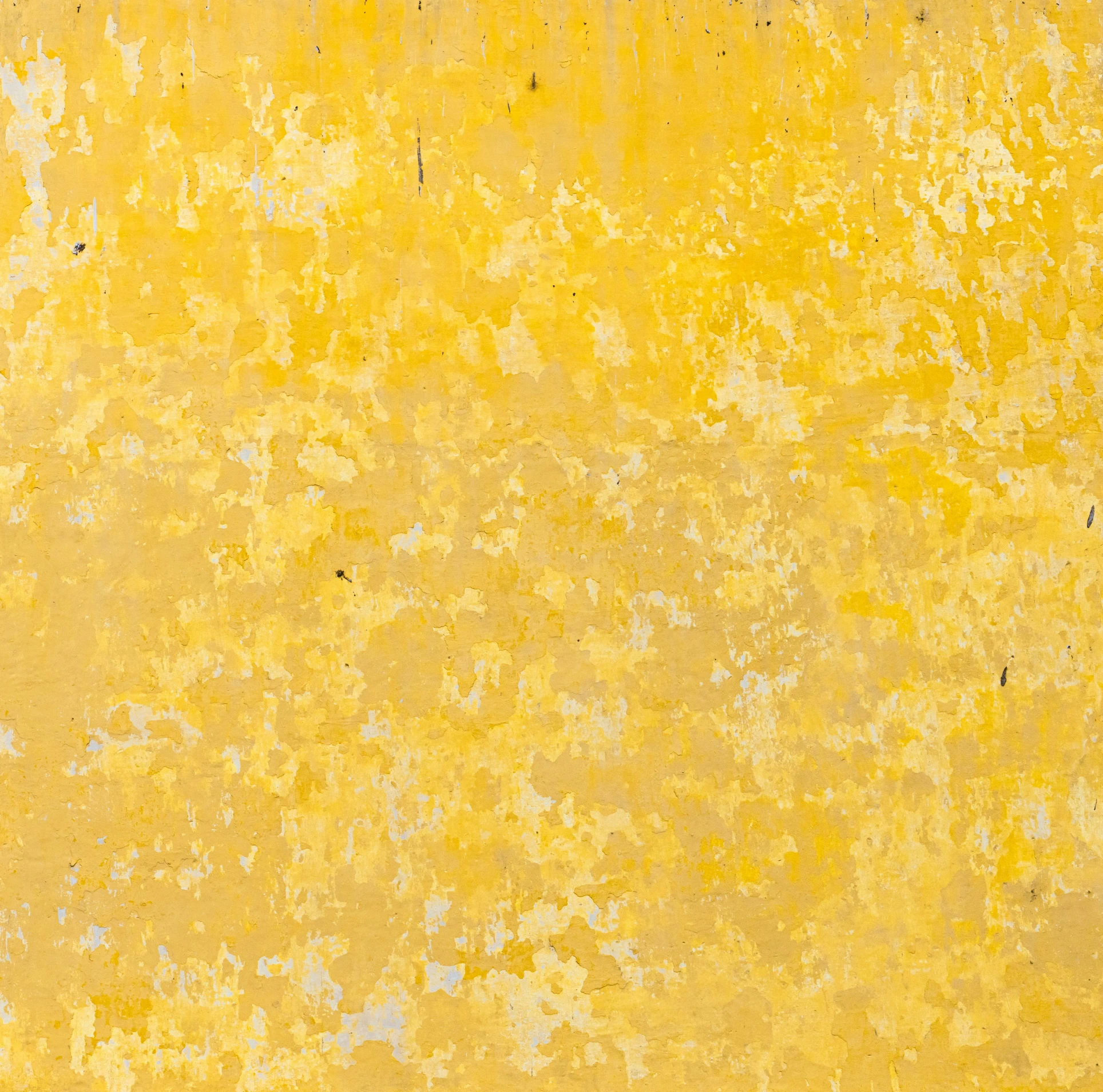 an old yellow wall with chipped paint with gray streaks