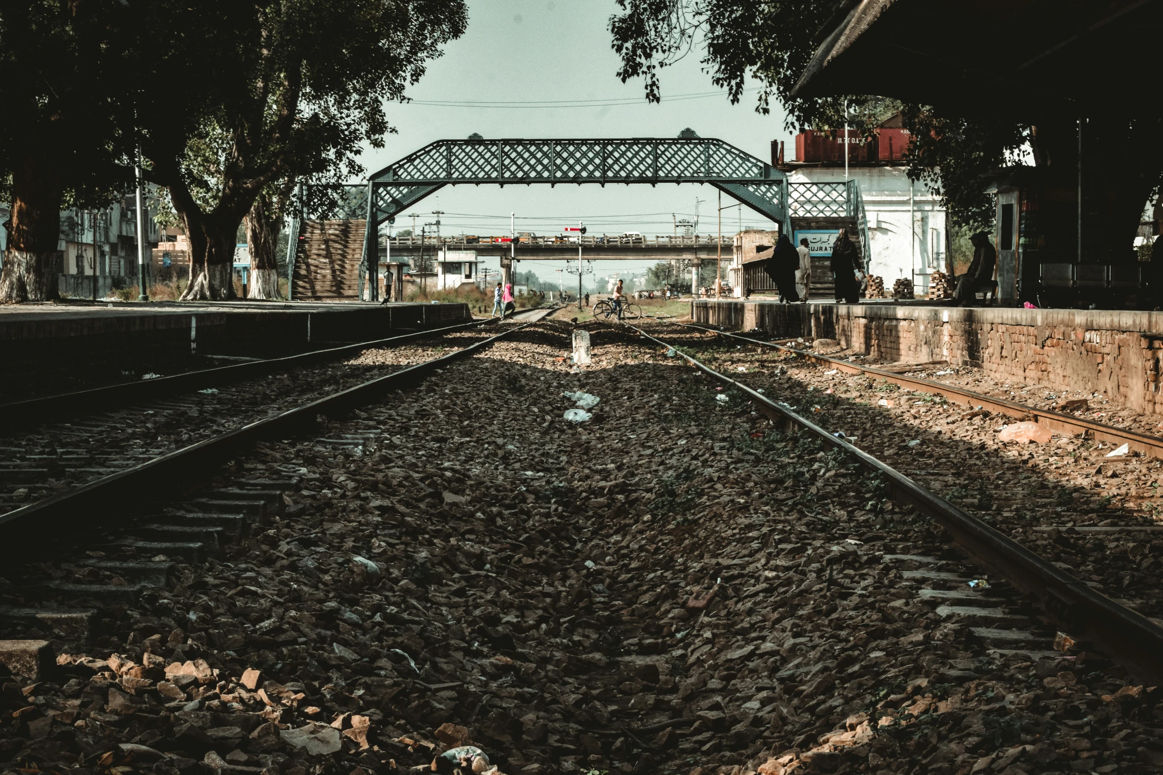 a train track sitting under an iron bridge