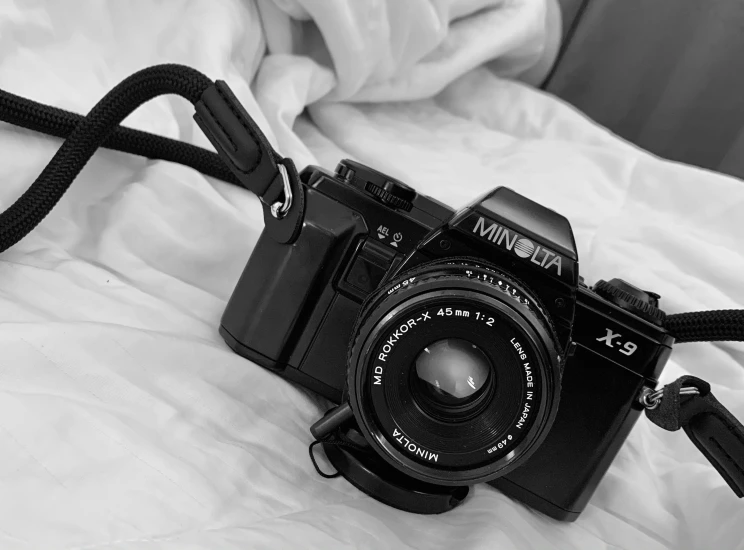 an old style camera sitting on top of a bed