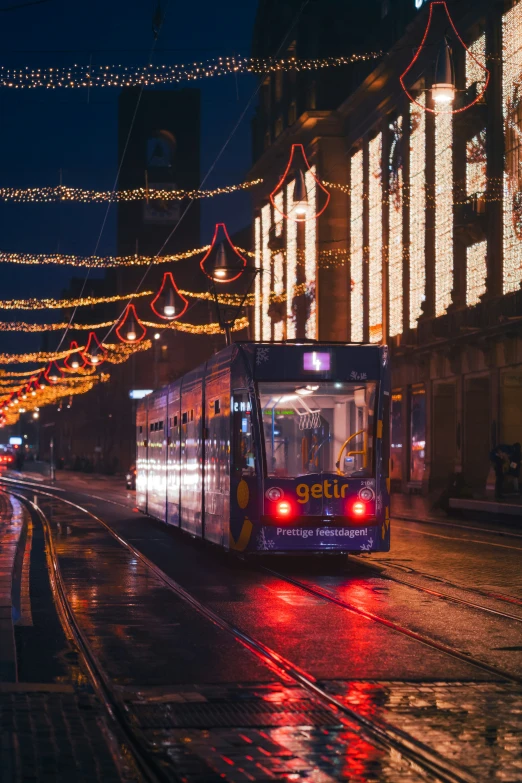 a tram on a city street with some lights around