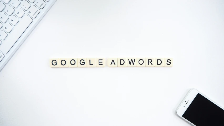 a computer keyboard sitting next to a keyboard that says google adwords